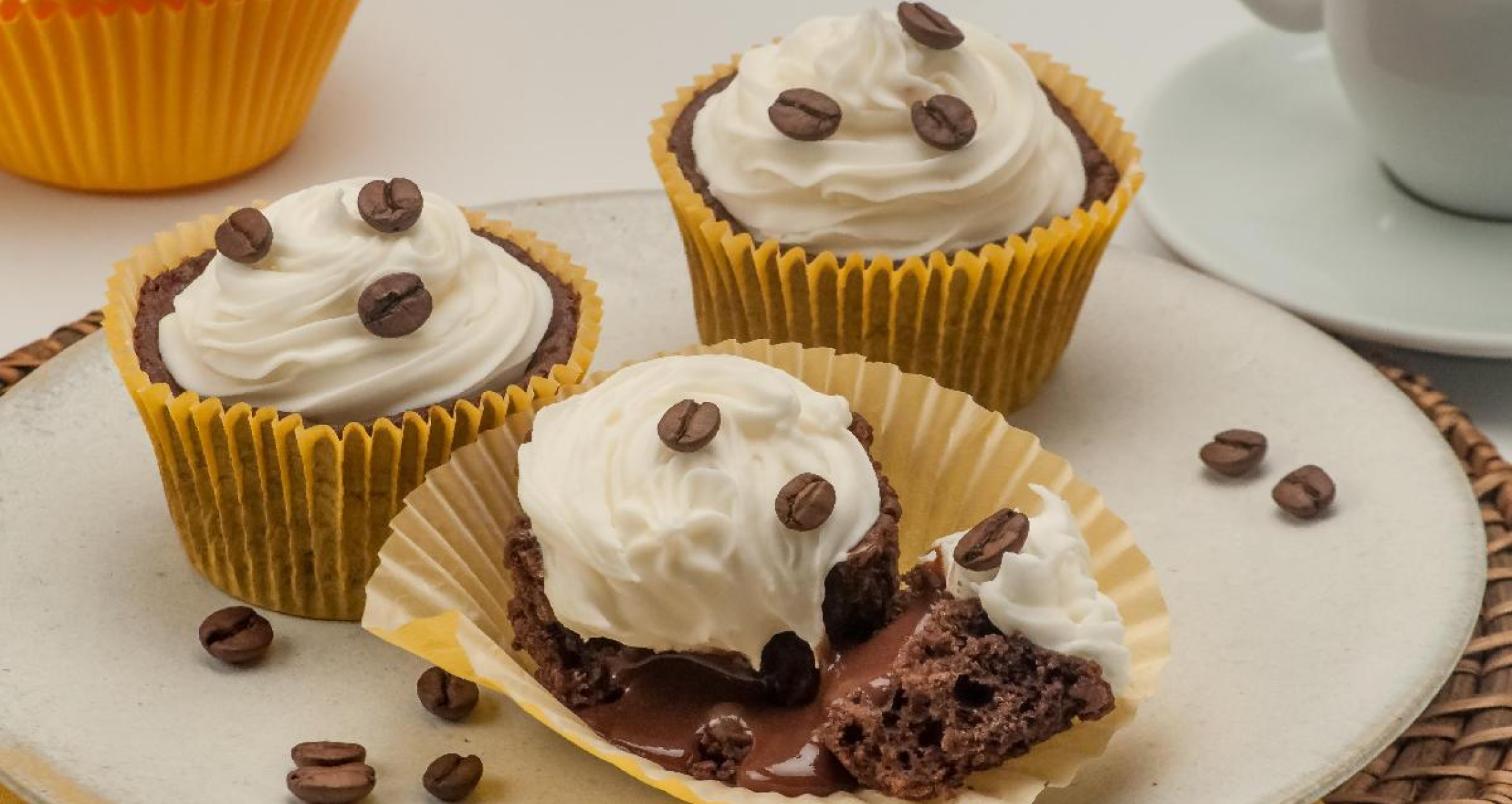 Imagem de um cupcake com grãos de café e chantilly